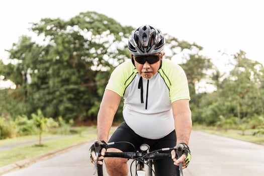 Senior hispanic man cycling on the road. photo