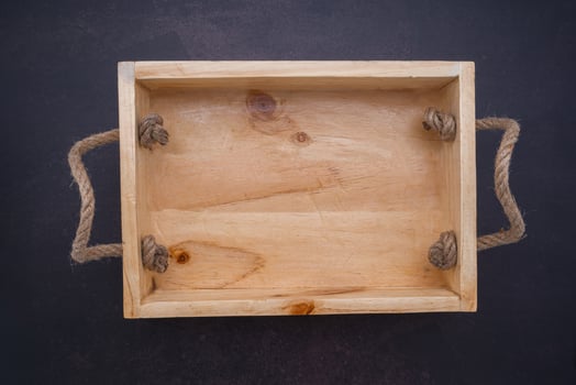 An empty wooden box is placed on dark stone background. Wood design. Space for text. Top view photo