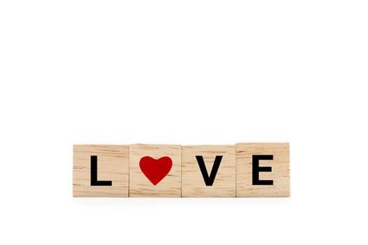 Hand place wooden blocks with LOVE text and red heart isolated on white background. Love symbol with copy space and clipping path. photo