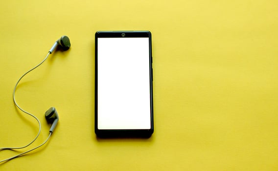 a cell phone on a yellow background with old style headphones photo