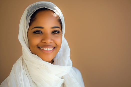 Smiling Woman Wearing White Hijab, Studio Background, Warm Tones, Expressive Eyes, Bright Smile, Traditional Attire, Cultural Representation, Portrait Photography, Headscarf Fashion, Confident Pose photo