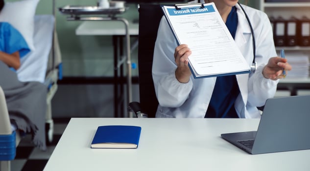 A beautiful and professional Asian female doctor is working on her medical cases on her laptop or making a call medical consultation with a patient while sitting in her office. photo