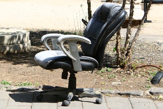 A lounge chair stands on the sidewalk on a street in a big city. photo