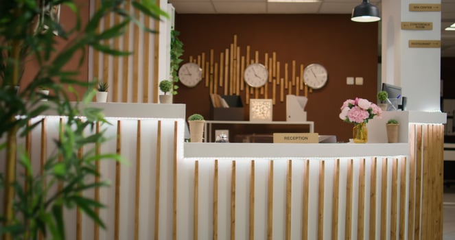 Interior of luxurious lobby at hotel, decorated with plants and posh furniture. Empty classy holiday resort with modern reception front desk ready to greet visitors, stylish marble floors. photo
