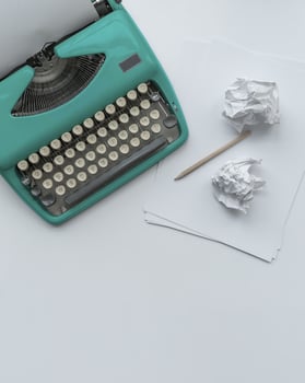 A vintage typewriter with paper sheets, stencil and paper balls. photo