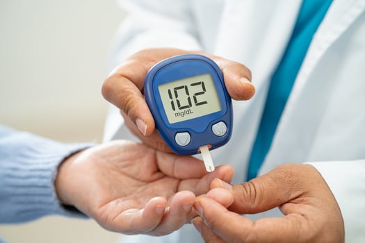 Doctor check diabetes from finger blood sugar level with finger lancet. photo
