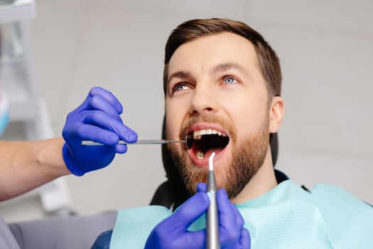 Man having teeth examined at dentists. Overview of dental caries prevention photo