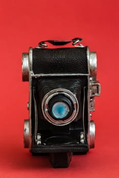 Decorative Nostalgic Camera Figurine on Red Background, Vintage Charm, Unique Perspective photo