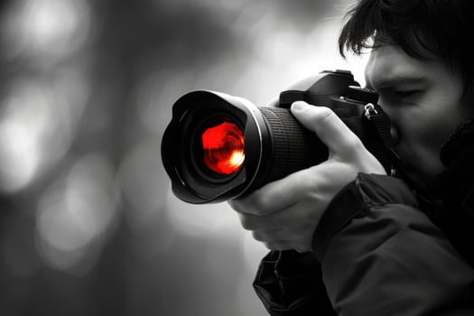 man hand holding camera looking through lens. photo