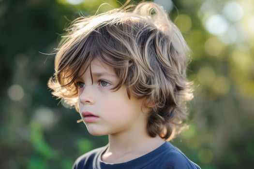 Pensive child outdoors with natural backlight photo