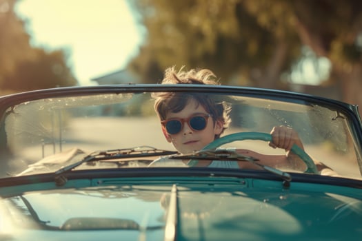 Cool kid pretending to drive vintage car photo