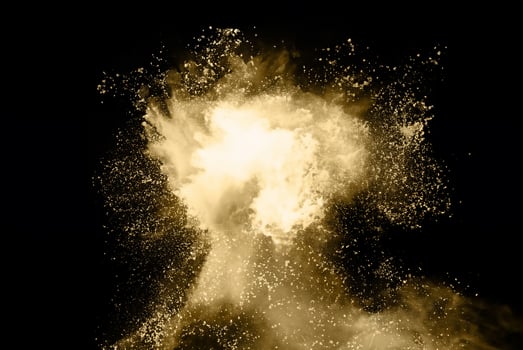 High-Speed Capture of Golden Powder Explosion on Dark Background photo