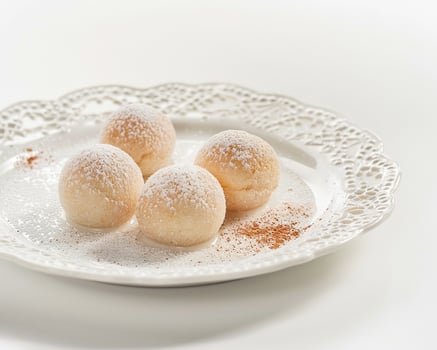 a white plate with four balls of sugar covered doughnuts photo