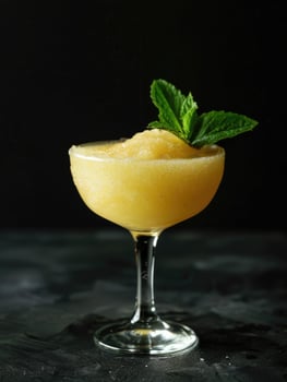 Frozen cocktail garnished with mint leaves in a glass. photo
