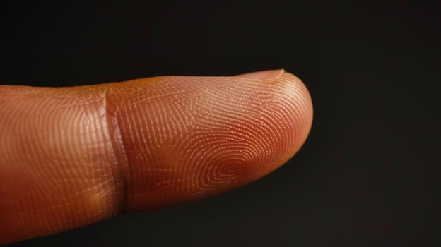 Finger with friction ridges on dark background, macro view photo