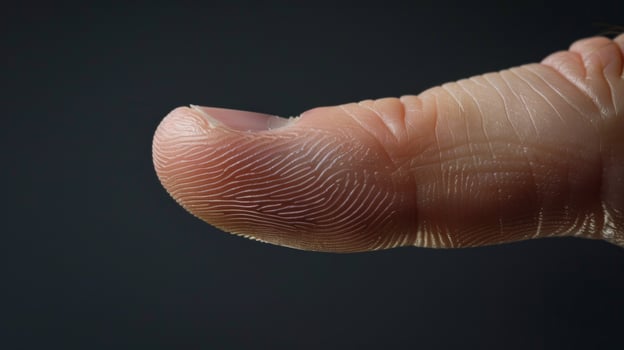 Finger with friction ridges on dark background, macro view photo