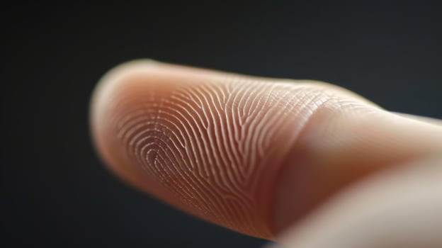 Finger with friction ridges on dark background, macro view photo