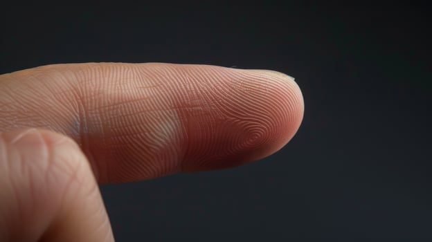Finger with friction ridges on dark background, macro view photo