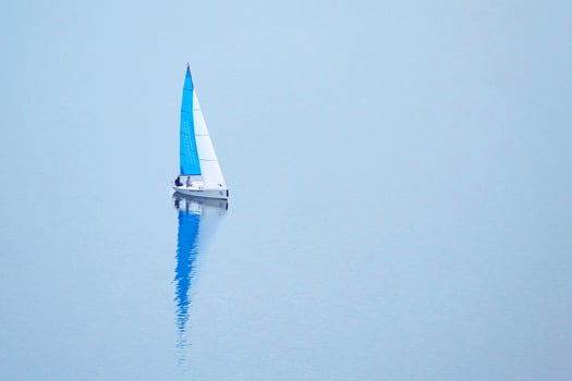 A small sailing ship on the light blue water photo