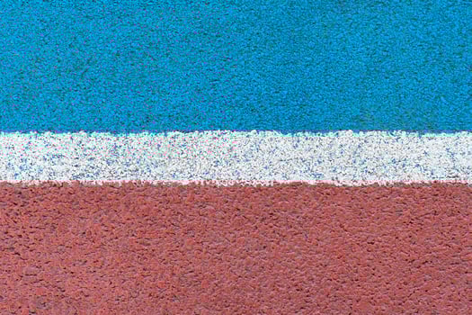 Blue - red tartan surface of athletics stadium with white horizontal line in the middle as texture, background photo