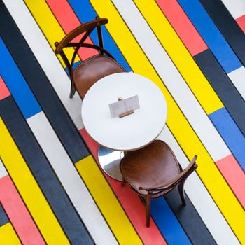 Top view on a round table and chairs on a multi-colored wooden floor in cafe photo