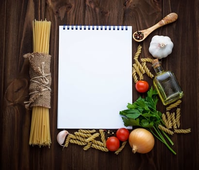 Tomato, pasta, garlic, parsley and empty notebook photo