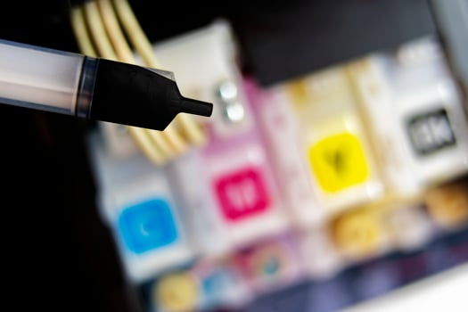 Closeup Refilling ink into a black ink tank printer at office photo