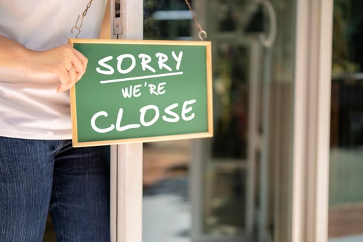 Asian restaurant owners are hanging a blackboard with the word closed photo
