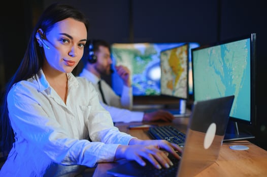 Friendly smiling woman call center operator with headset using computer at office photo