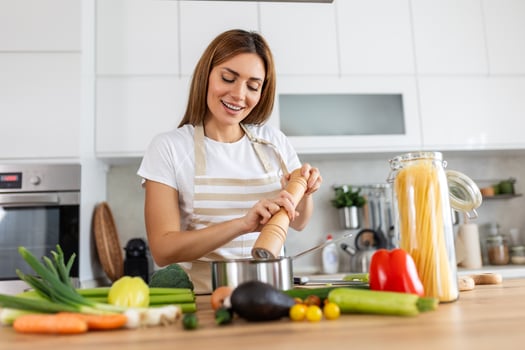 Happy Young Woman Cooking Tasting Dinner In A Pot Standing In Modern Kitchen At Home. Housewife Preparing Healthy Food Smiling . Household And Nutrition. Dieting Recipes Concept photo