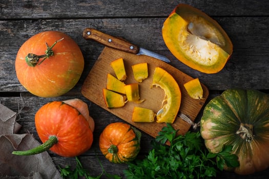 Raw chopped pumpkin on wooden background photo