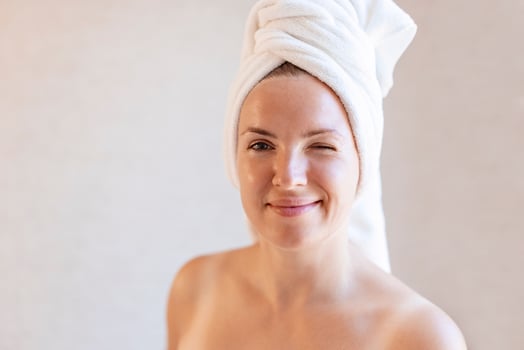 Woman with a towel wrapped around her head winking and looking at camera photo