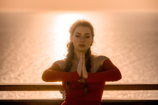 Closeup portrait of sensual young brunette woman in red dress, happily dancing outdoors isolated on blurry sea background with natural bokeh in soft warm sunset backlight. Selective focus. photo