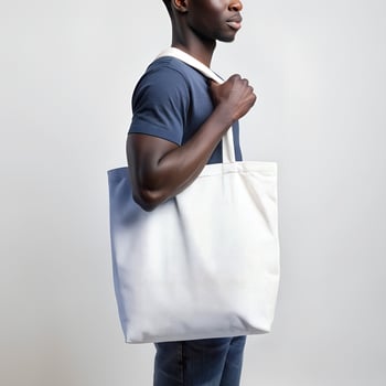 Tote bag mockup. Young African American man carrying reusable cotton linen eco organic fabric canvas blank totebag on white background. photo