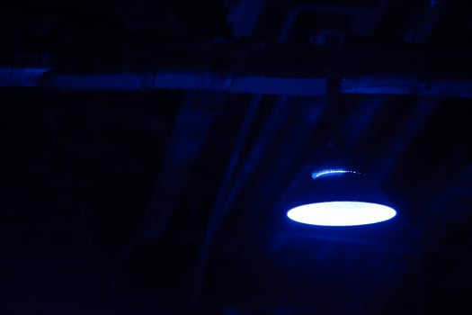 Old hanging lamp in the factory at night. Industrial night scene. Attic. Interior style with space for text. photo