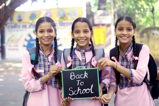 Three Girl Schoolmates Looking At The Camera While Going To School photo