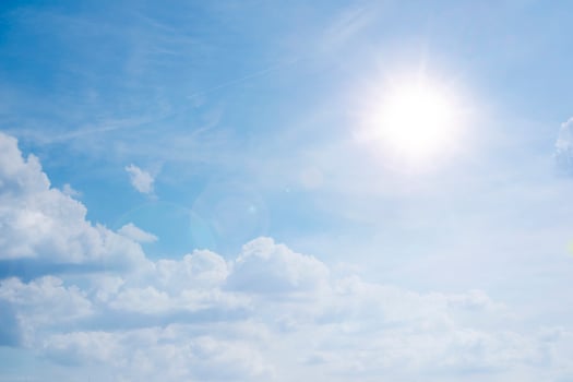 blue sky background with white clouds concept. The sun shines in a starry sky photo