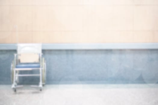 Abstract blur luxury hospital hall. Blur clinic corridor interior background with wheelchair, defocused effect. Healthcare and medical concept photo