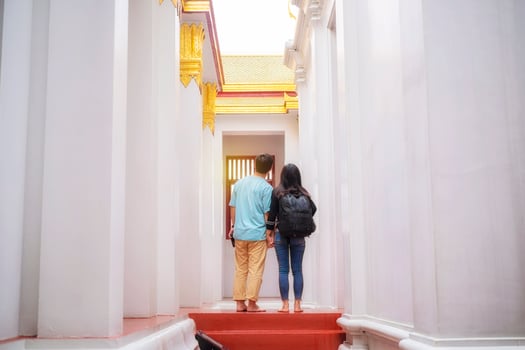 Young Asian tourists enjoy visiting Thai temples during their holidays in Bangkok, Thailand. photo