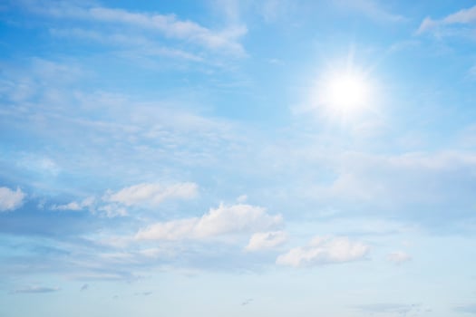 The sky is full of clouds floating around, both small and large, the sun is shining brightly photo