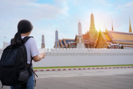 Asian girls look at a map about Wat Phra Kaew to travel in the Grand Palace in Bangkok, Thailand. photo