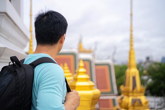 A young Asian with a backpack loves to visit Thai temples during the summer vacation in Bangkok. photo