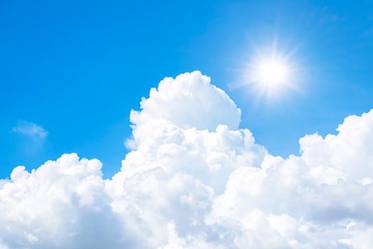 The sky is full of clouds floating around, both small and large, the sun is shining brightly photo