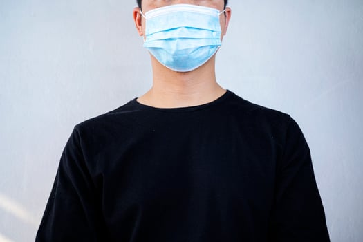 blue medical mask on face for personal protection during coronavirus COVID-19 pandemic photo