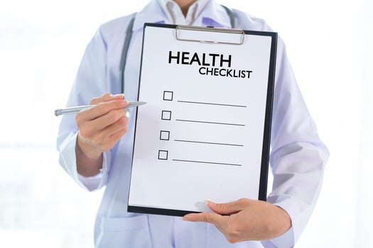 Doctor holding clipboard and writing HEALTH CHECK photo