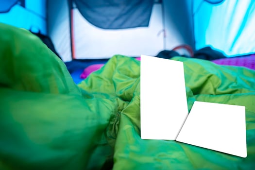 A blank postcard placed on a sleeping bag that was in the tent. photo