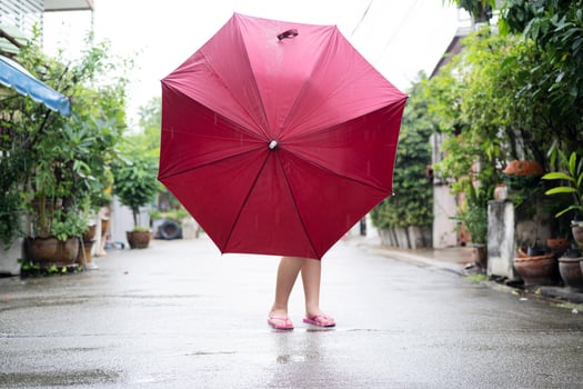 A little girl holding a red umbrella stood in the middle photo