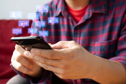 man hand using smartphone with colorful application icons around photo