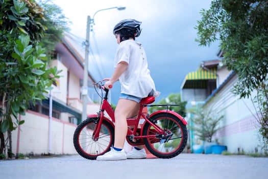 Children learning to drive a bicycle on a driveway outside. photo