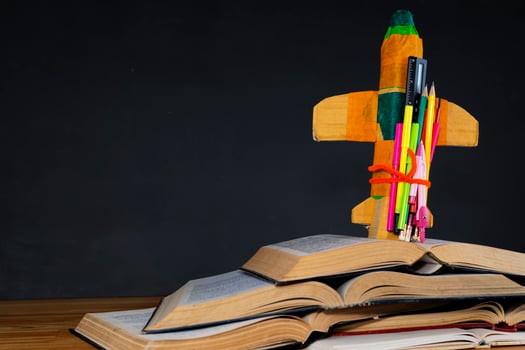 Education and back to school concept. cardboard rocket and pencils over books photo